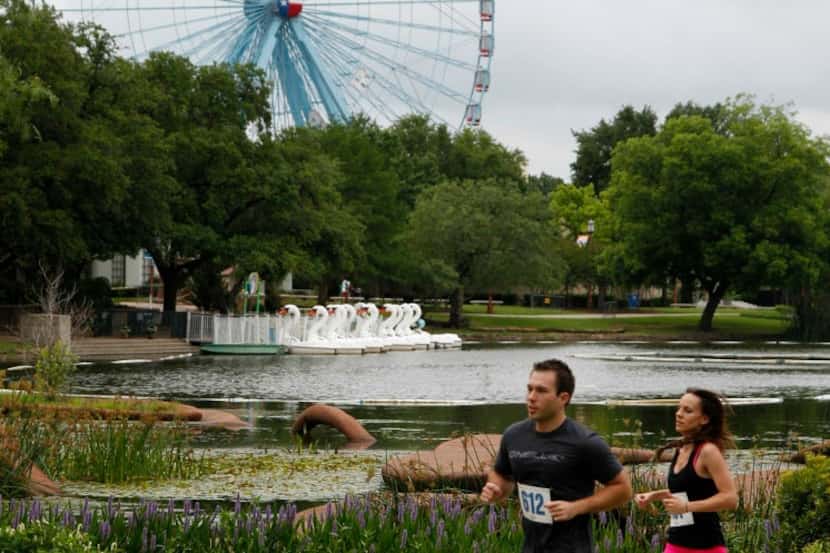 Runners pass the Leonhardt Lagoon and Texas Star at Fair Park.