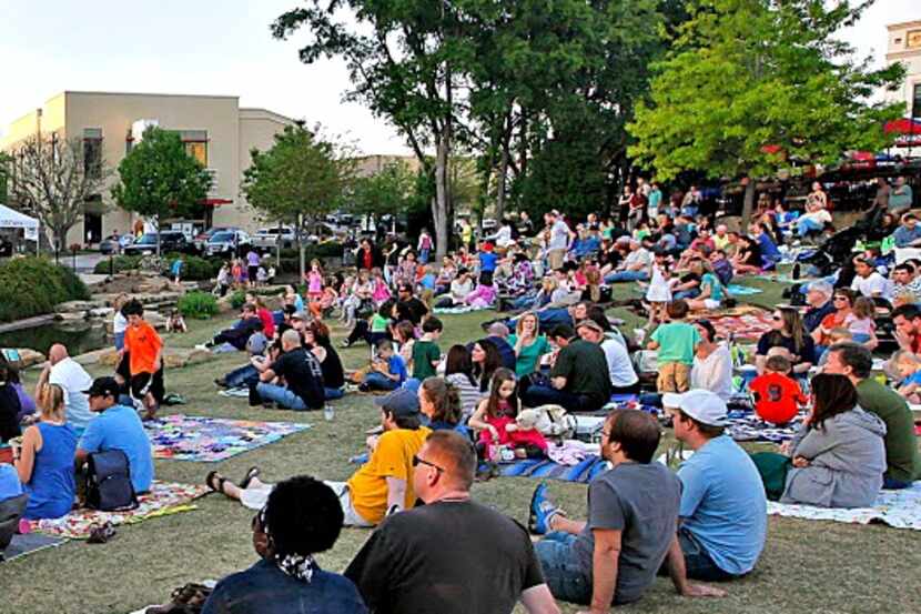 A large crowd gathers on blankets for an outdoor concert at Watters Creek in Allen. 