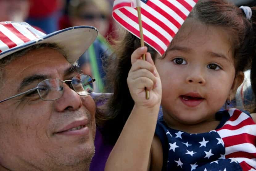 Decked in patriotic colors, Jose Flores and his granddaughter watch the 2016 Arlington...
