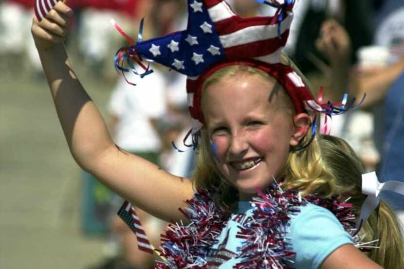 A girls waves her flag at the annual Plano Fourth of July parade.  