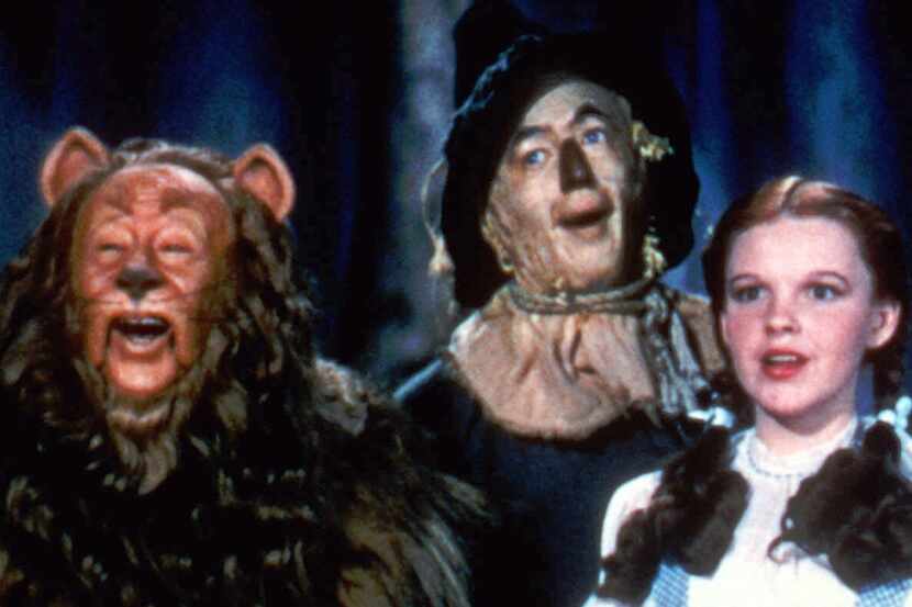 Bert Lahr as the Cowardly Lion, Ray Bolger as the Scarecrow and Judy Garland as Dorothy in...