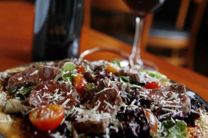 The Steak Pizza dish and red wine is available at Cru wine bar.
