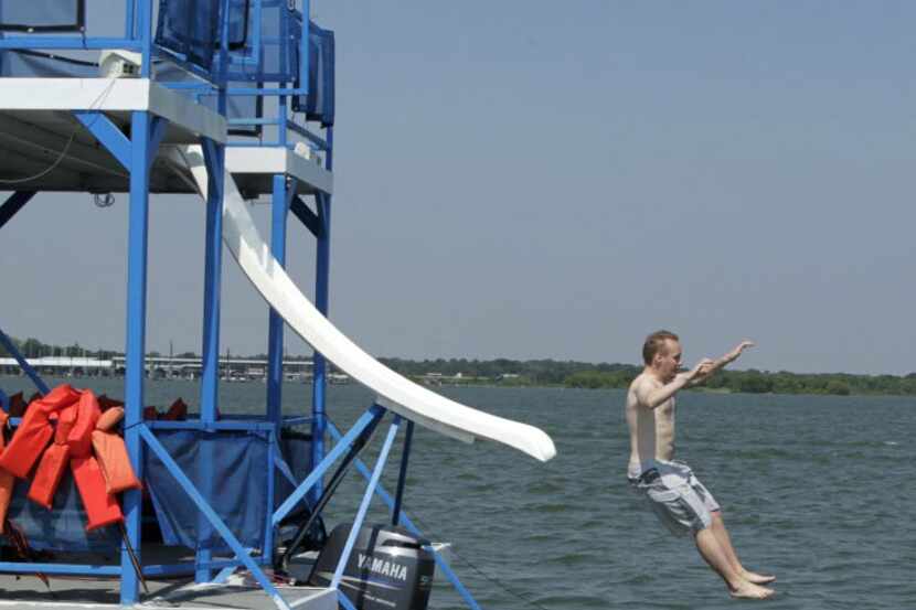 A man slides into the water from a party boat on Lake Lewisville. 