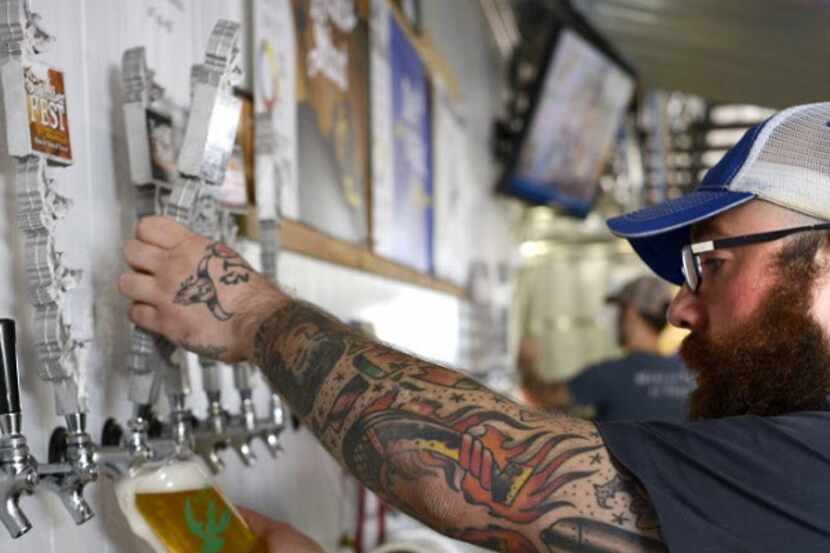 Volunteer bartender James Herrington pours a beer during a tasting and tour event at Martin...