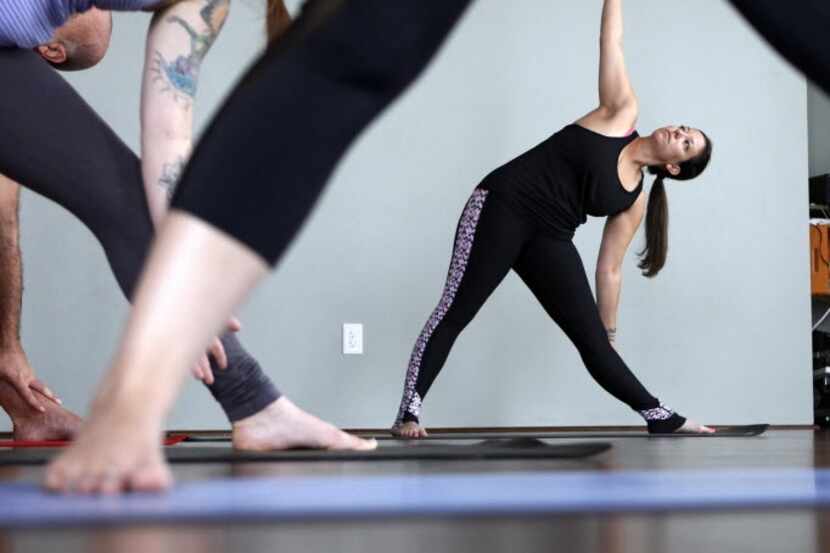 Shana Stein makes a pose during a yoga class, on Saturday, April 16, 2016 at Sync Yoga &...