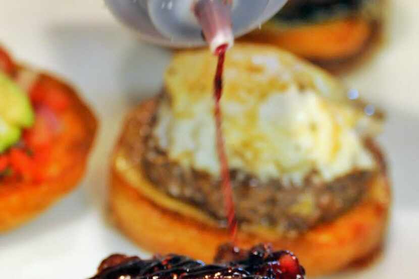 Blackberry compote is drizzled over bacon and beef patty for the Mike Rawlings burger at...