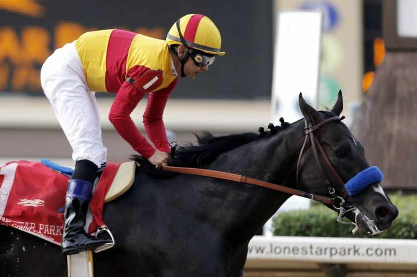 Jockey Mike Smith rides Danzing Candy across the finish line at Lone Star Park in Grand...