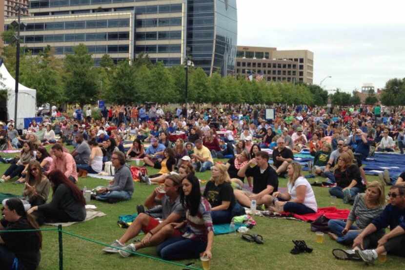 Visitors to Klyde Warren Park sit on the lawn for a free concert.