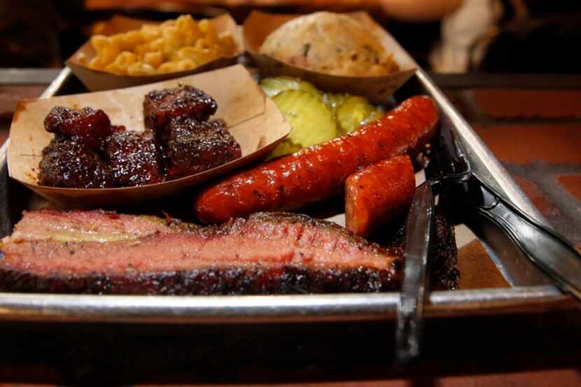 A tray full of C.A.B. brisket, burnt ends, sausage, Green Chile Mac & Cheese and Twice Baked...