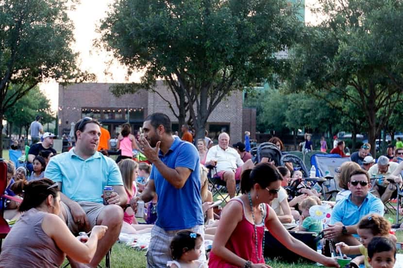 Guests sit in lawn chairs and on blankets for a summer concert series.