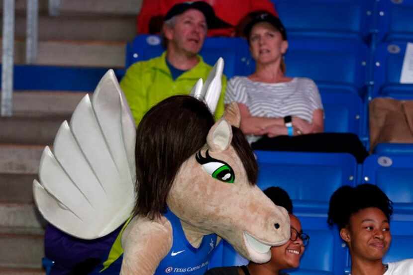 Lightning, the Dallas Wings mascot, takes a photo with fans.