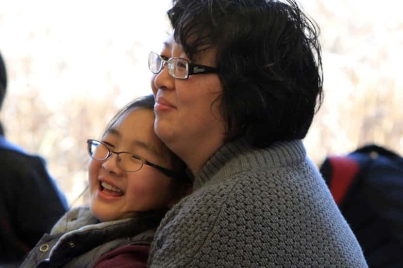 Hong Guo and her daughter enjoy a performance at the library.