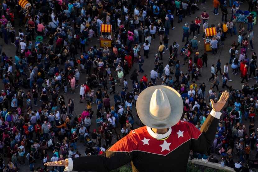 The last rays of sunlight fall over Big Tex as crowds fill the State Fair of Texas.