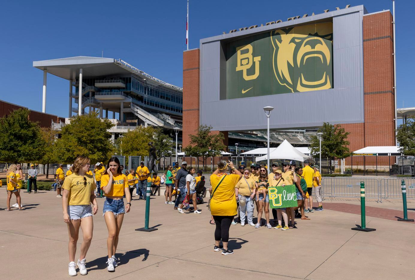 People pose for photos before an NCAA football game between Baylor University and Oklahoma...