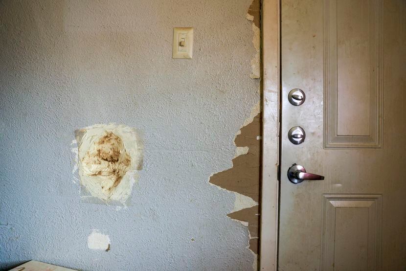 Holes and missing paint line the wall near the front door of Destiny Morris’ home at the...