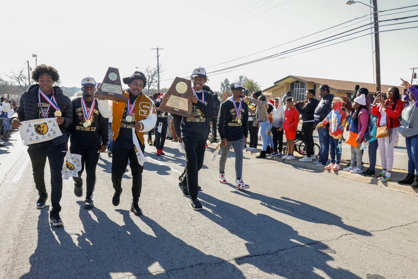Members of the South Oak Cliff team carry their trophies during a parade celebrating South...