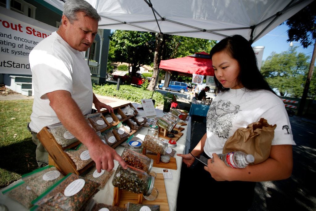 Rick Stricklin, left, of the Sprout Stand, talks to Catherine Nguyen at the McKinney Farmers...