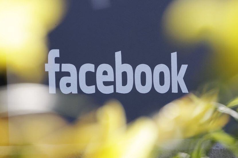 This Friday, May 18, 2012, file photo shows a sign at Facebook's headquarters behind flowers...