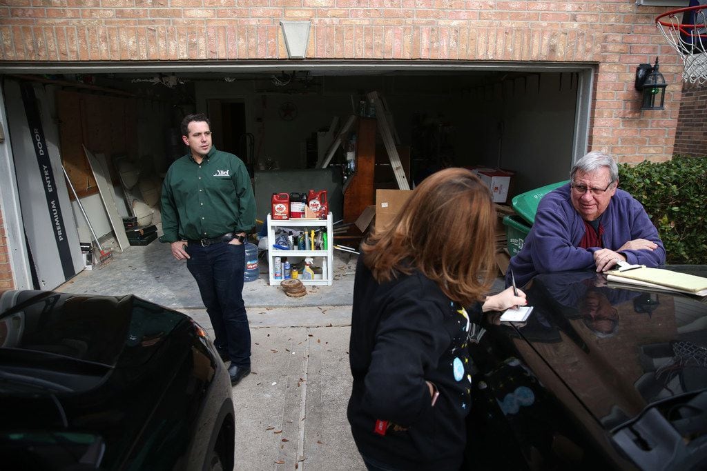 Bryan Brown (left) watches as his wife, Colleen, writes a check for their contractor Mike...