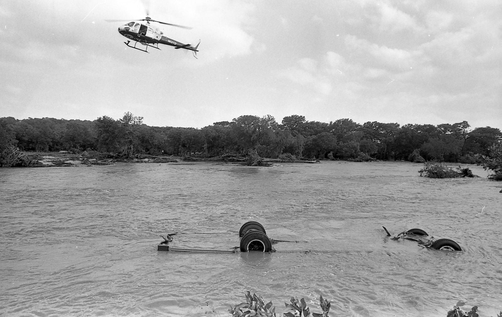 A helicopter hovers over the Seagoville Road Baptist Church bus swept away by floodwater on July 17, 1987.