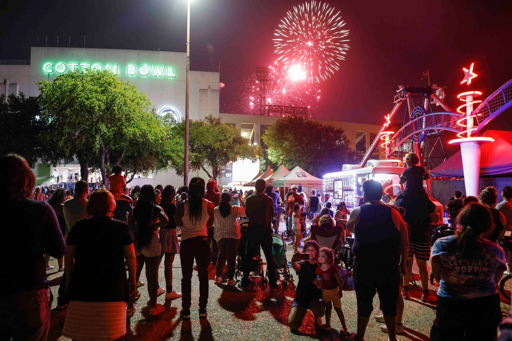 People watch as the fireworks explode during an Independence Day celebration on Monday, July...