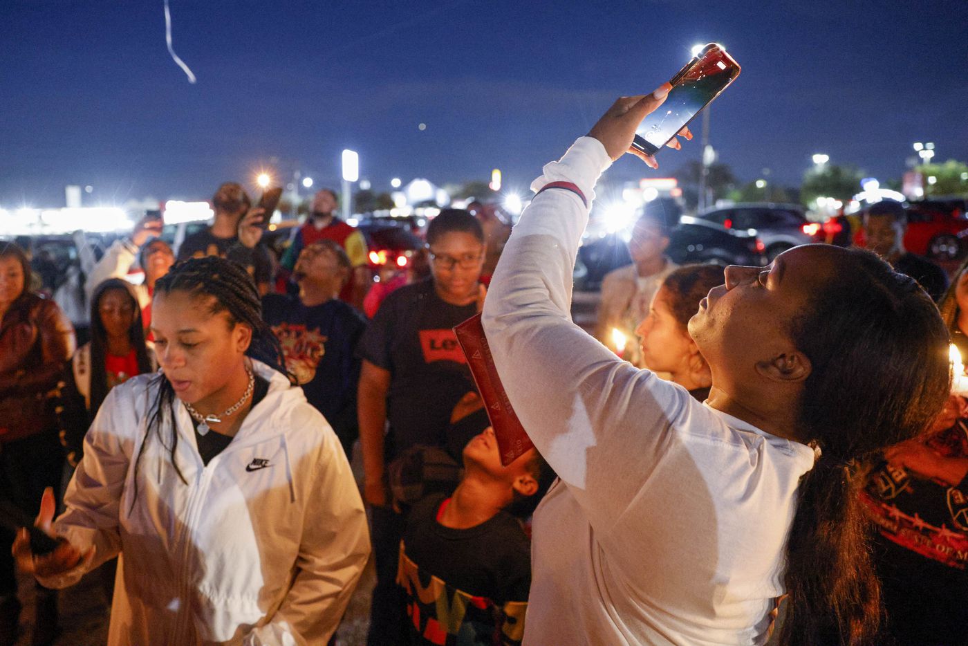 Monic Amor records a video after a balloon release in memory of 11-year-old De’Evan McFall...