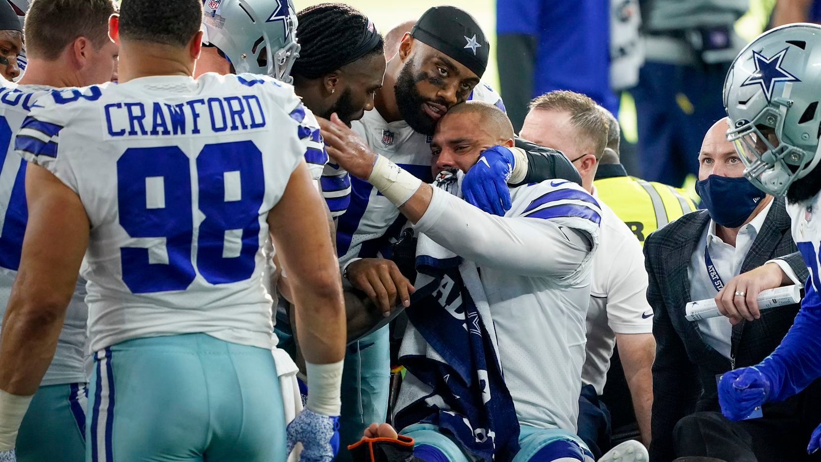 Dallas Cowboys quarterback Dak Prescott lis consoled by teammates as he leaves the field on...