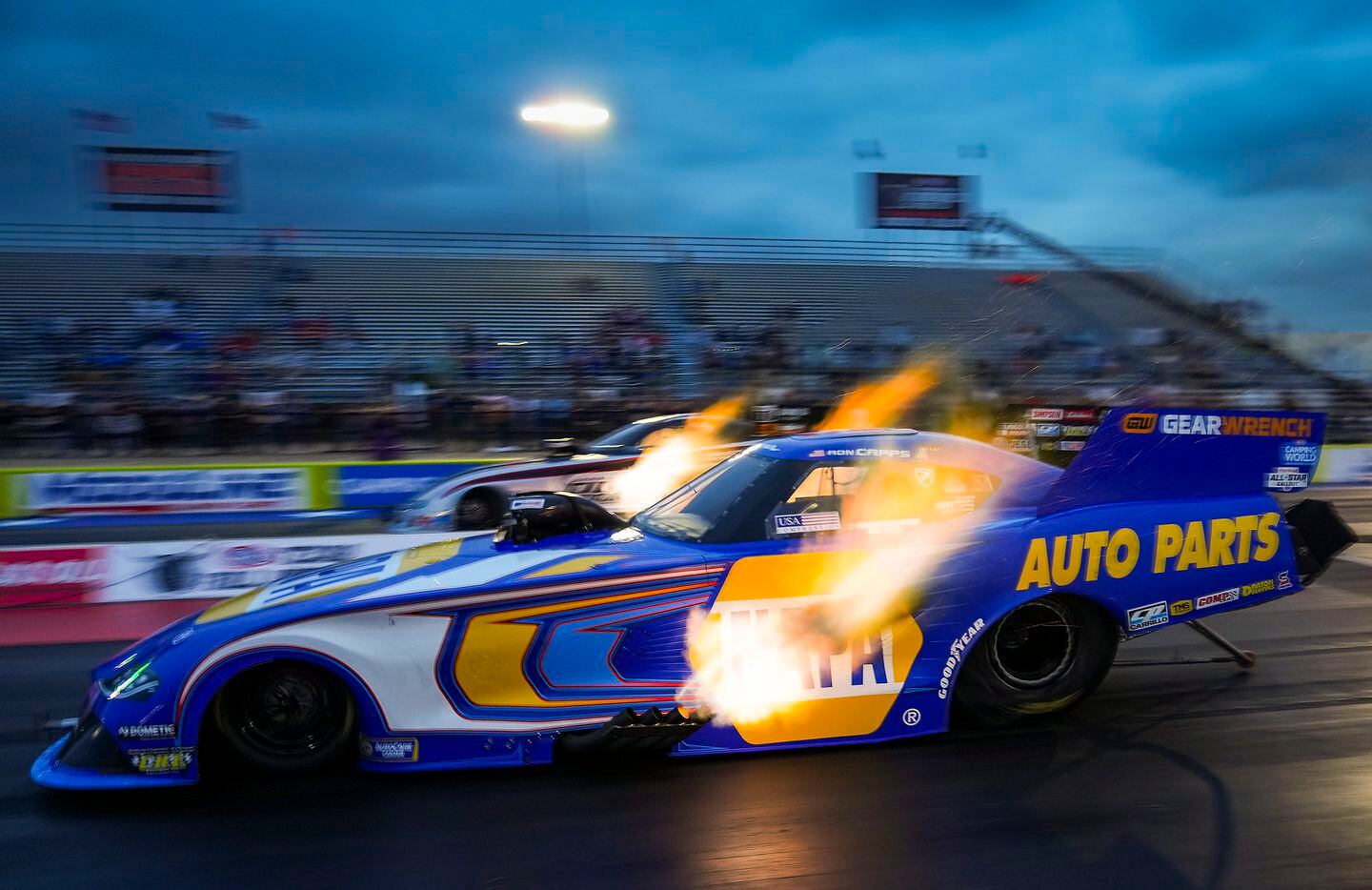 Ron Capps (front) comes off the line crew at the start of his Funny Car finals victory over...