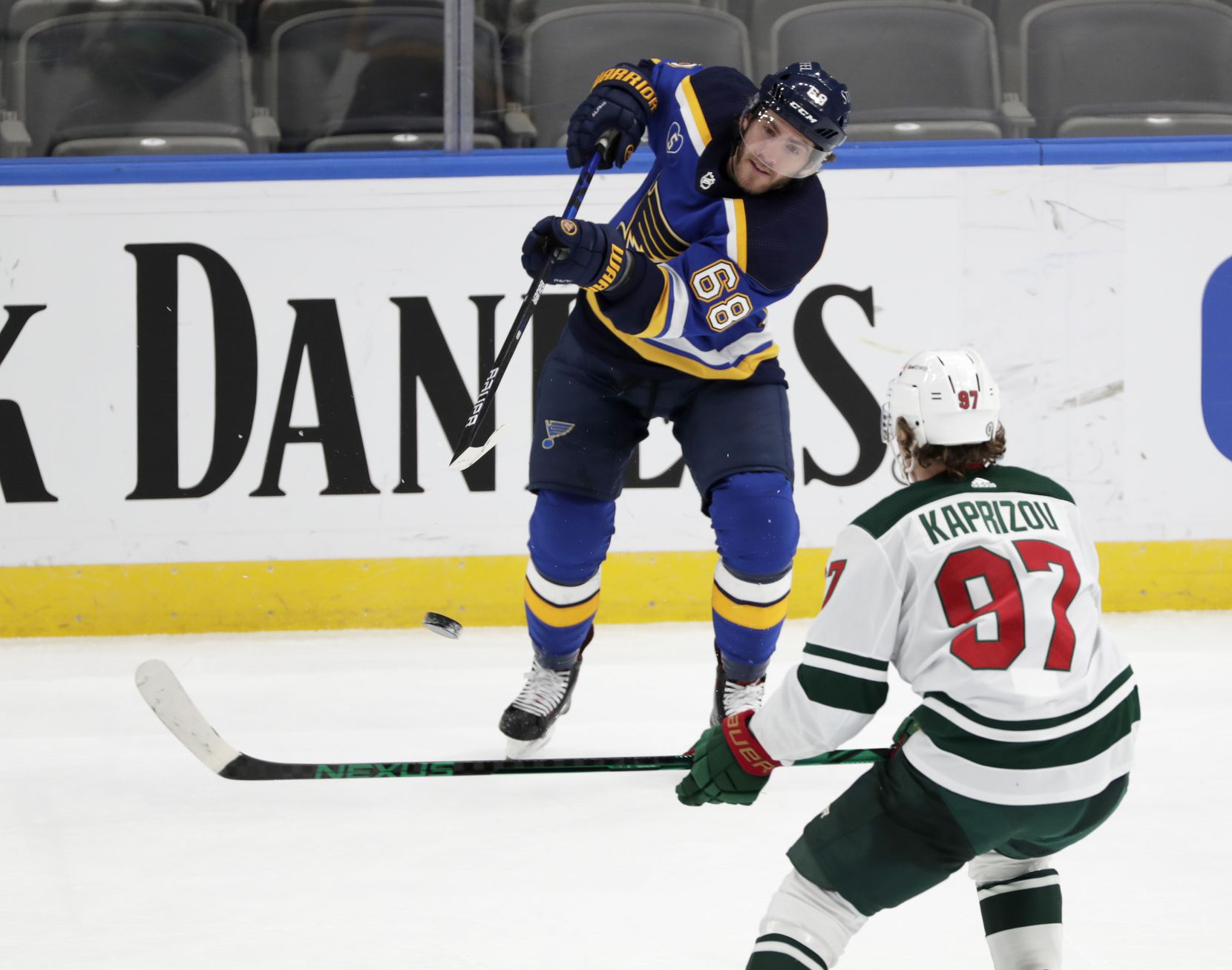 St. Louis Blues' Mike Hoffman (68) flips the puck past Minnesota Wild's Kirill Kaprizov (97) in the third period of an NHL hockey game, Wednesday, May 12, 2021 in St. Louis. The Blues beat the Wild 4-0.