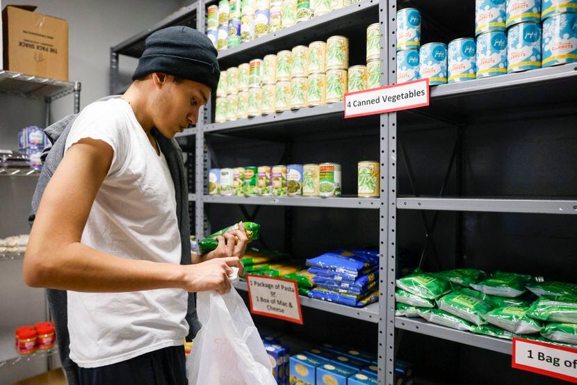 Student Roberto Reyes, 18, grabs a bag of pasta from the food pantry at Dallas College...