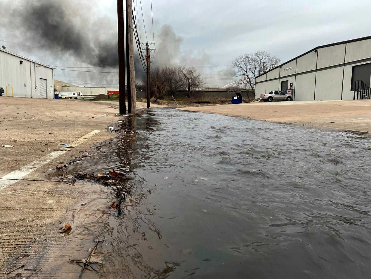 Dark water from a large 5-alarm fire at the Advanced Foam Recycling facility runs through the industrial district in Fort Worth, Texas, Thursday, February 25, 2021. The water was used to fight the fire at the company that recycles materials to be processed and used for carpet underlay, pillows, and furniture, according to the company website. One twenty five firefighters from Richland Hills, Haltom City, North Richland Hills and Fort Worth firefighters assisted on the commercial structure fire in the 2500 block of Handley Ederville Road in E. Fort Worth. (Tom Fox/The Dallas Morning News)