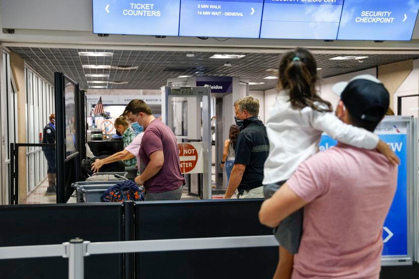 Un grupo de pasajeros pasa por un punto de revisión de TSA en el aeropuerto Dallas - Fort...