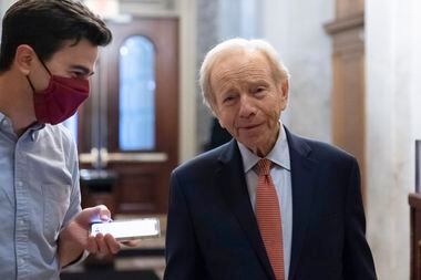 Former Sen. Joe Lieberman of Conn., right, speaks with a reporter at the Capitol in...