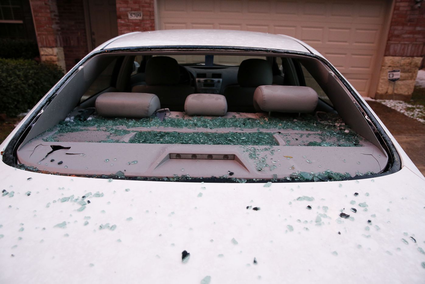 A car with a broken windshield after hail pounded houses and cars in McKinney on Sunday