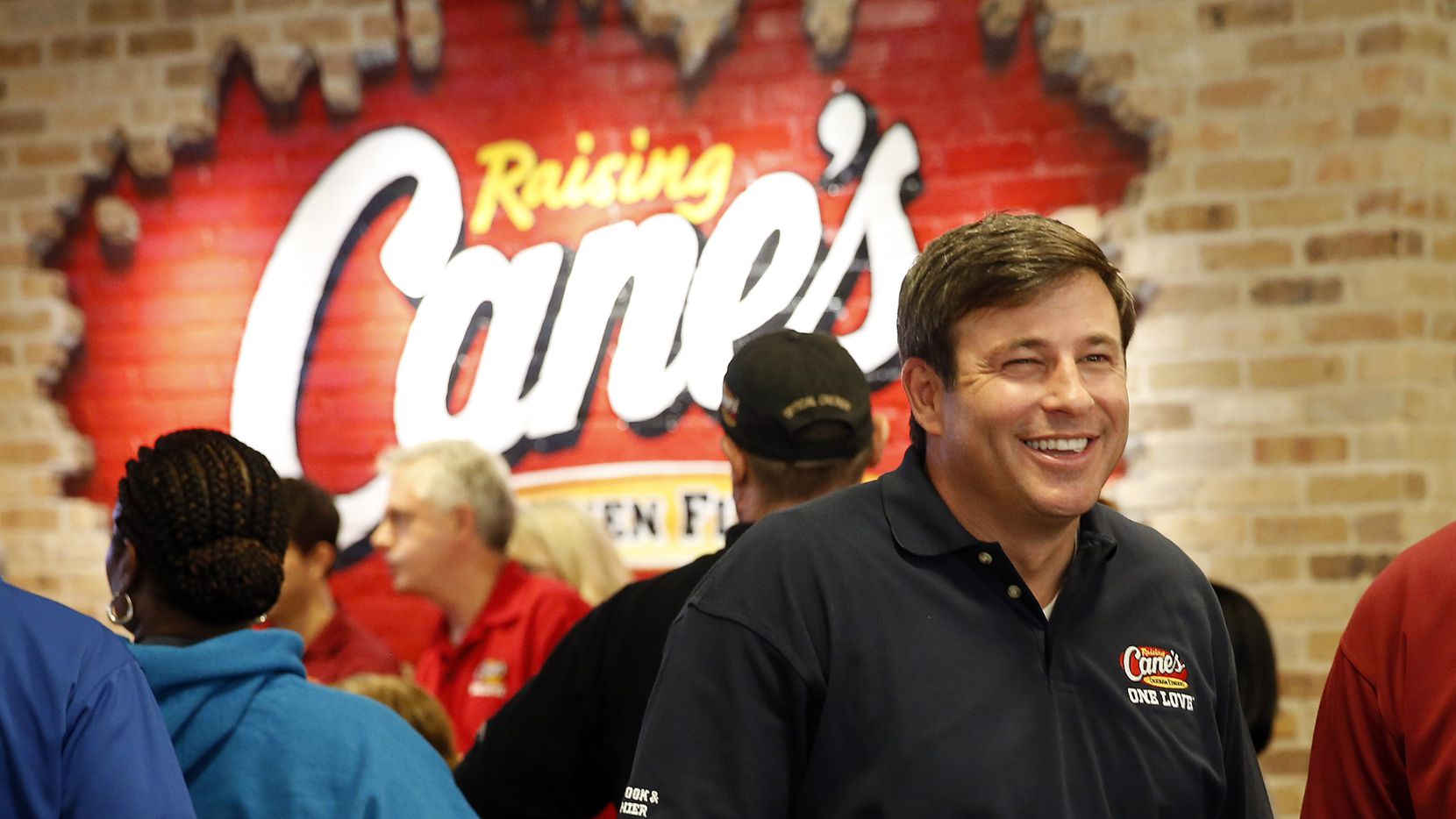 Raising Cane's Chicken Fingers founder Todd Graves (right) visits with employees at their...