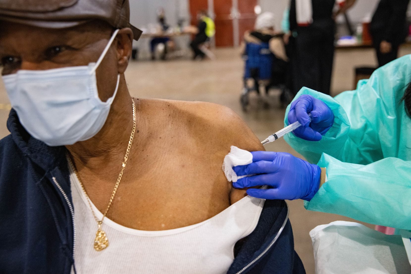 Verely Cooper, 81, of DeSoto looks away as he receives the COVID-19 vaccine at Fair Park in Dallas on Thursday, January 14, 2021. A limited number of COVID-19 vaccines will be available Thursday at Fair Park for children. North Texans 75 and over.  (Juan Figueroa / The Dallas Morning News)