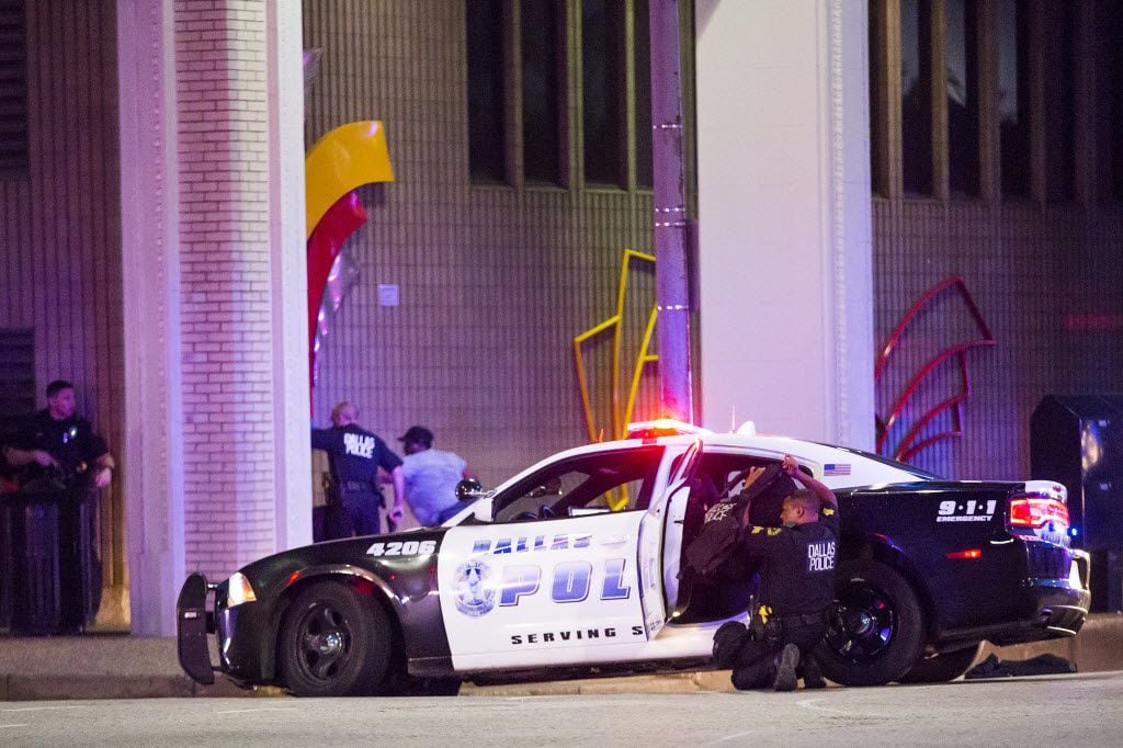 Dallas Police shield bystanders after shots fired at a Black Lives Matter rally in downtown...