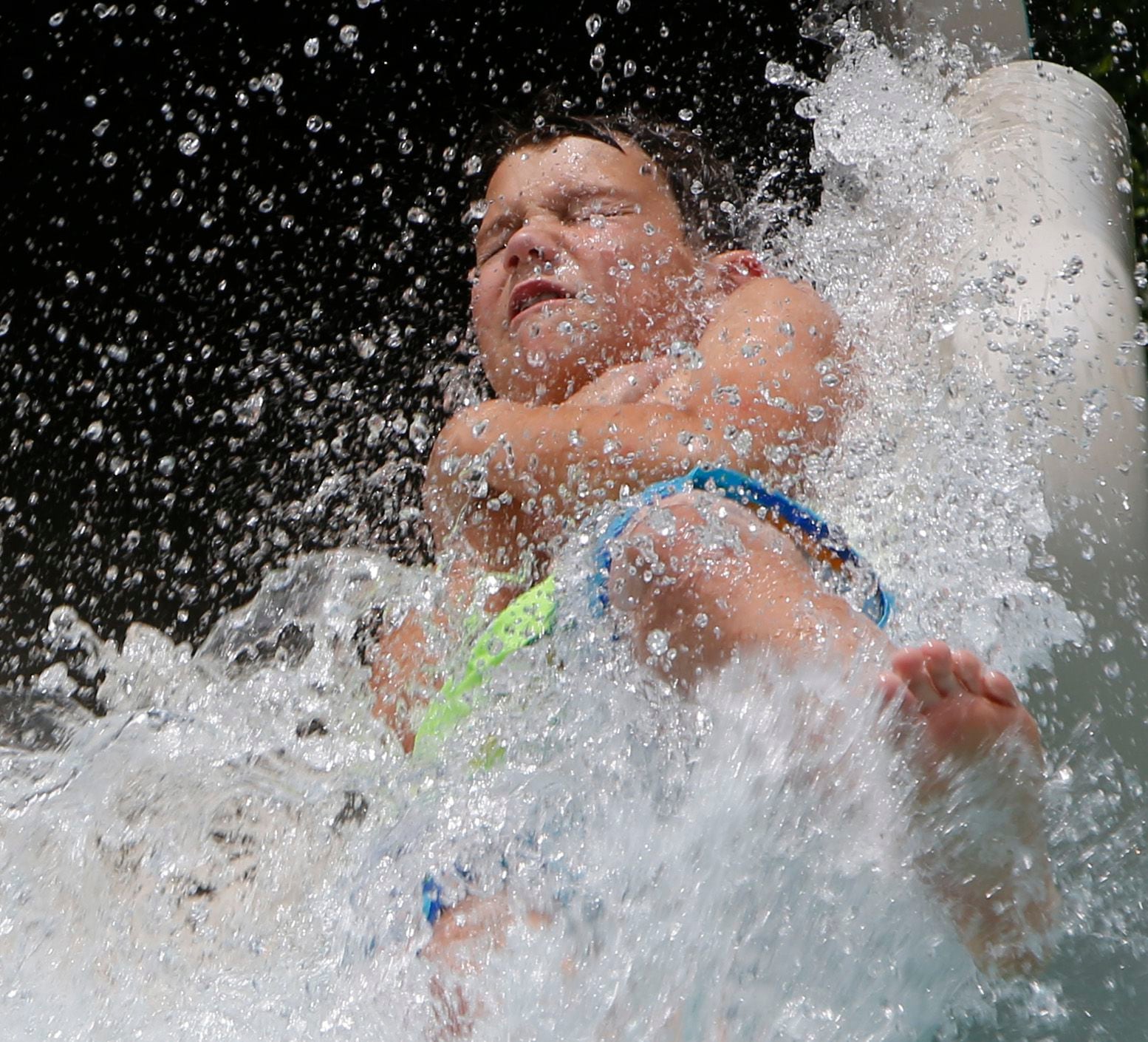 Elijah Koelpin, 11, makes quite a splash as he flies from a covered slide. 