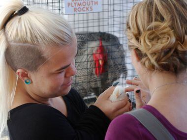 Caylea Woodbury, left, holds a baby chick as Amanda Loy pets its head at Big Texas...
