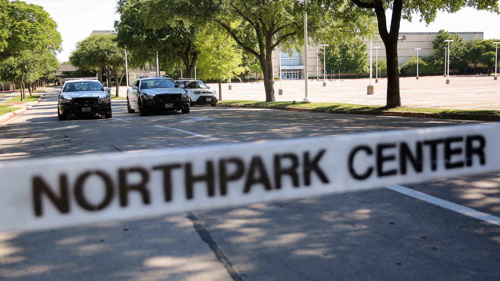 Police officers guard the Park Lane entrance to NorthPark shopping center after reports of a...