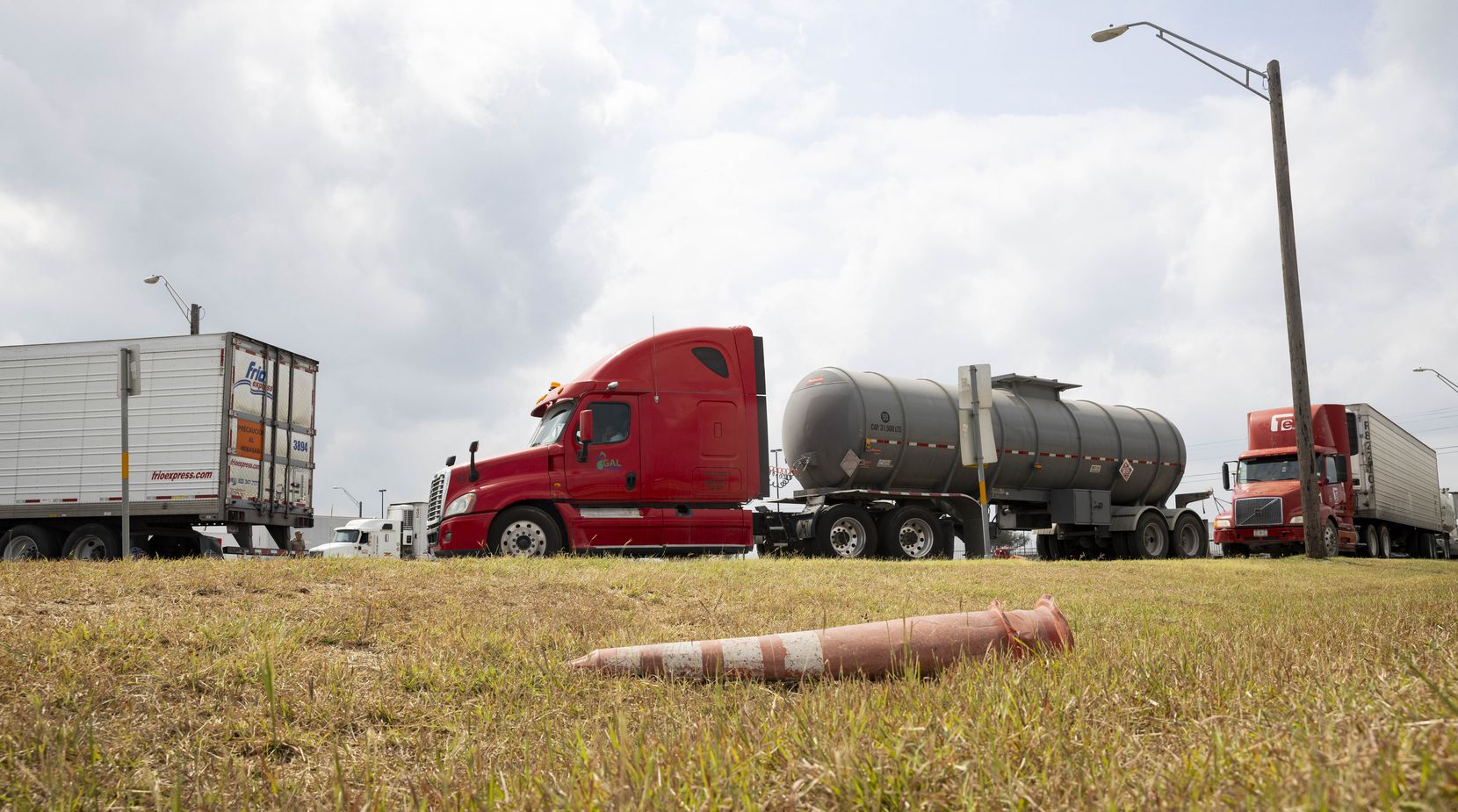 Trucks wait to be inspected by Texas State troopers at an inspection site close to the...