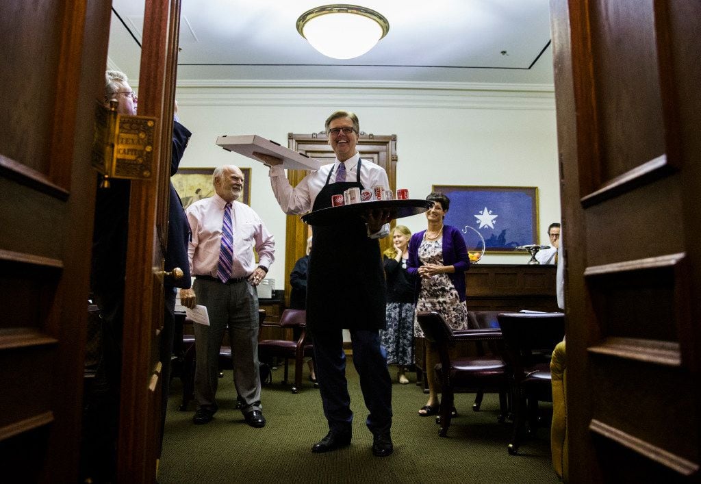 Lt. Gov. Dan Patrick holds pizza and soda inside the Senators' Room just before the Senate reconvenes at 12:01 a.m. for a third reading of the Sunset Bill during the third day of a special legislative session on Thursday at the Texas Capitol in Austin. 