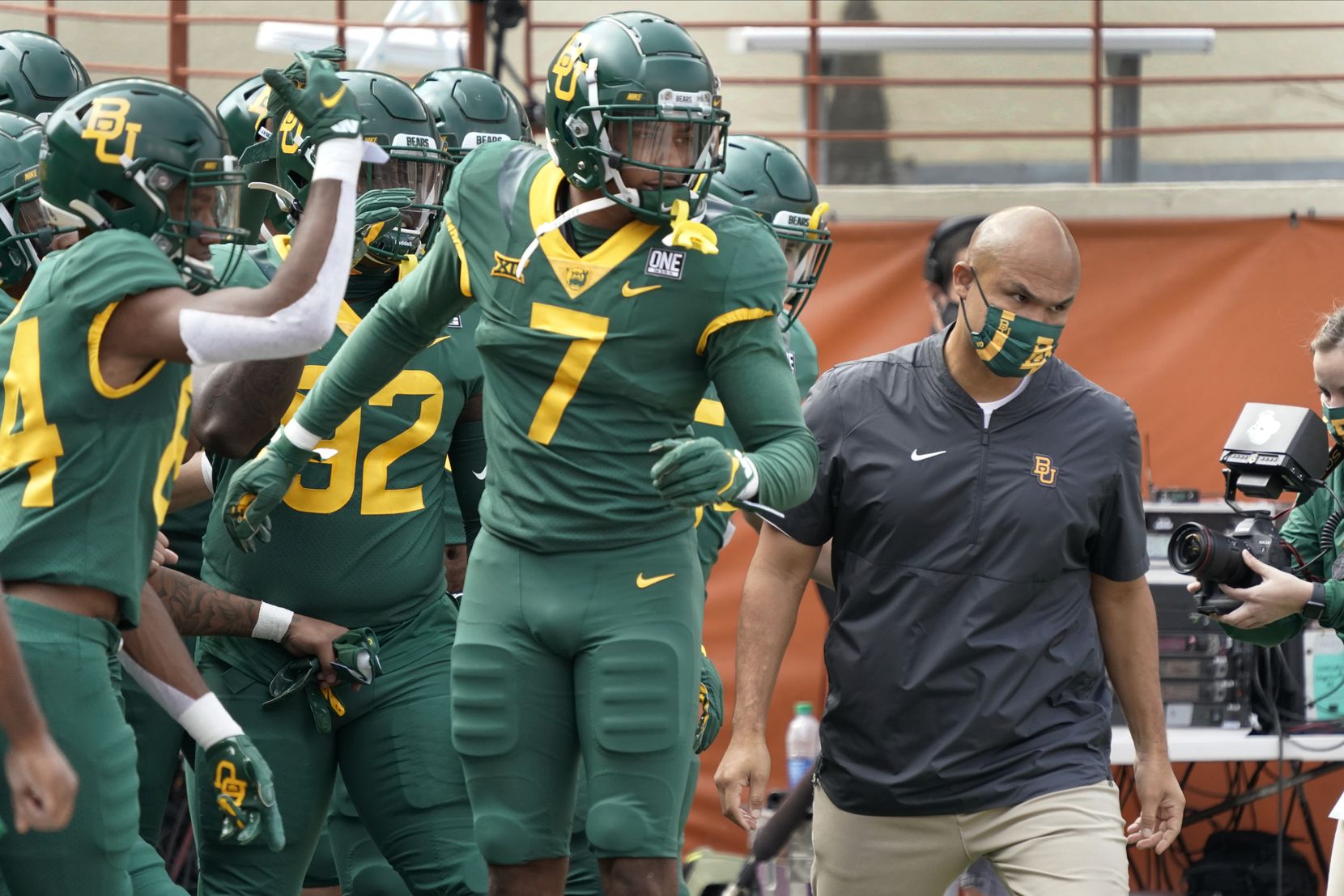 Baylor head coach Dave Aranda, right, leads his team onto the field before an NCAA college...