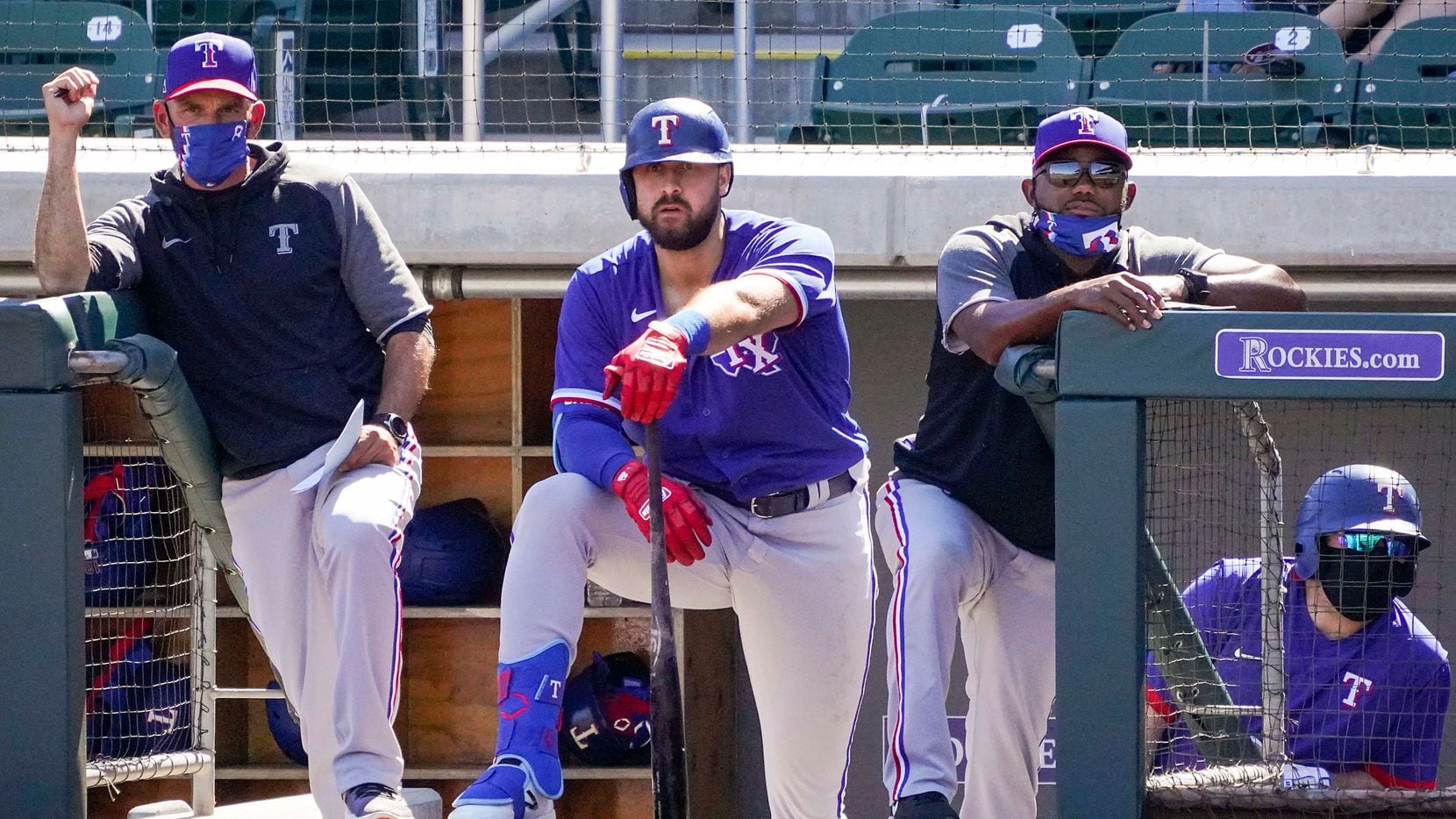 Texas Rangers manager Chris Woodward (left), outfielder Joey Gallo (center) and assistant hitting coach Callix Crabbe watch from the dugout during the third inning of a spring training game against the Arizona Diamondbacks at Salt River Fields at Talking Stick on Saturday, March 6, 2021, in Scottsdale, Ariz.