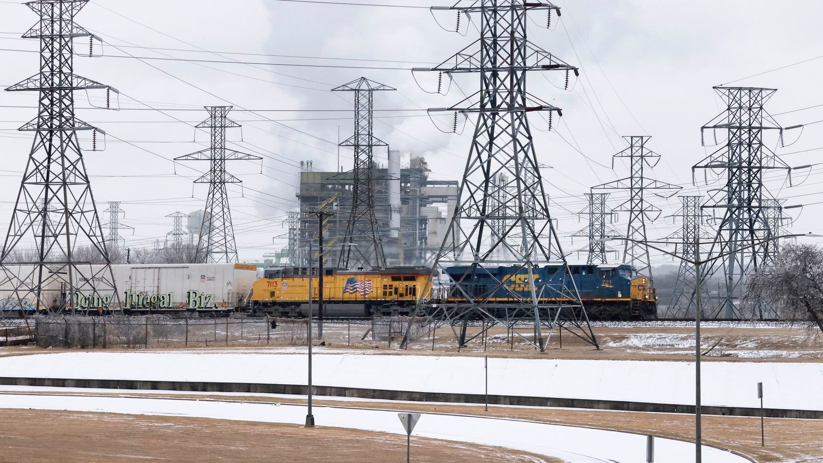 A CSX and Union Pacific train passes by the Handley Generating Station in East Fort Worth,...