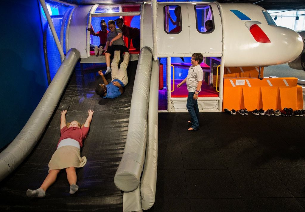 Ava Howard (bottom), 10, slides down a airplane evacuation playground with her classmates during a tour of American Airlines C.R. Smith Museum on Thursday, August 23, 2018 in Fort Worth. The newly renovated museum reopens Labor Day Weekend. (Ryan Michalesko/The Dallas Morning News)