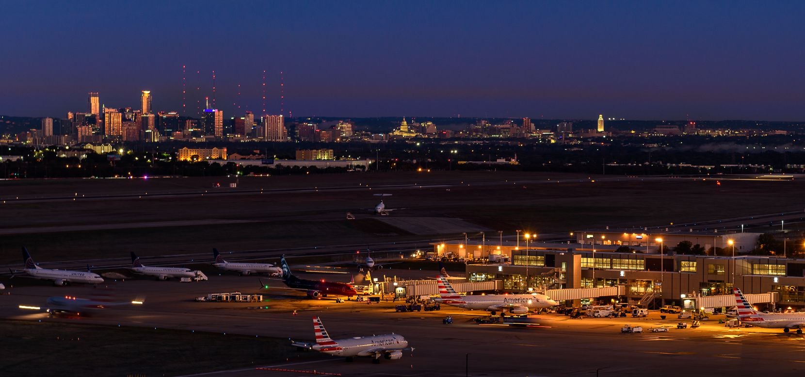 A nighttime view of Austin-Bergstrom International Airport with the city of Austin in the distance.Image downloaded from the airport's media images site.