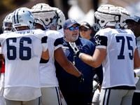 Dallas Cowboys head coach Mike McCarthy steps in and settles his offensive players who were...