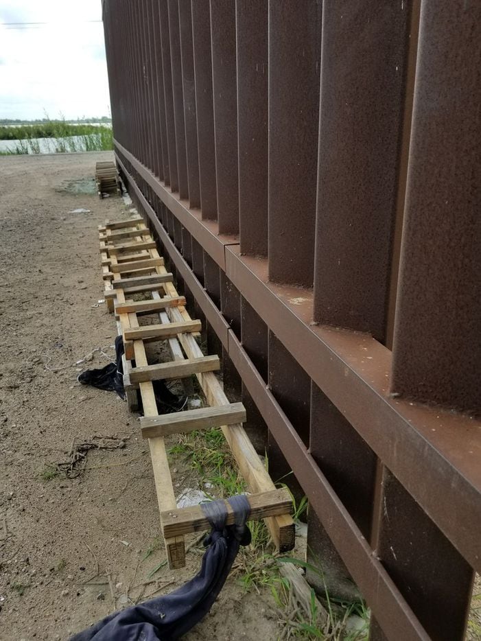 Makeshift wooden ladders collected by the Border Patrol lay next to the border wall in...