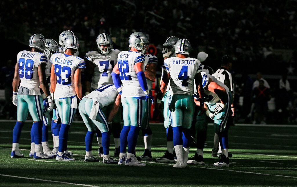 The Dallas offense, led by quarterback Dak Prescott (4) huddles in the fourth quarter during...